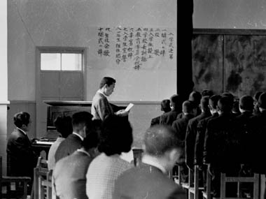 呼名をするKUさんと入学式次第の張り紙。