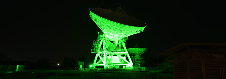 グリーンライトにライトアップされた奥州市VLBI20ｍ電波望遠鏡の様子。