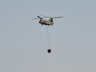 ＣＨ−４７Ｊ大型ヘリが水の入ったバケットをつり上げています。