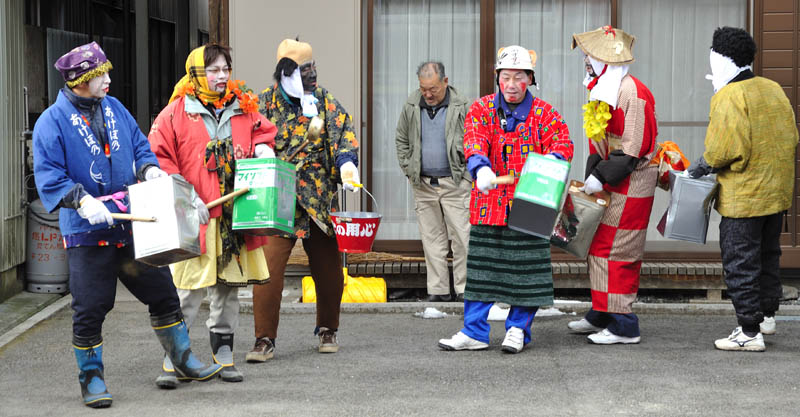 住田町・奇習水しぎの一団が家の前で一斗缶を叩きながらぐるぐると廻る様子です。