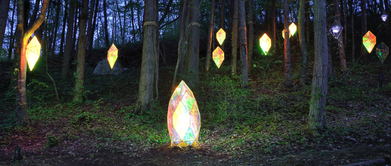 森の木々の間に偏光フィルターで輝くダイヤモンド模様のステンドグラス