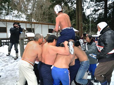 境内での争奪戦 7・・・手にした御福銭をまく男性。