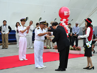 歓迎式典で白川船長からお返しのプレゼントをもらう大船渡市長。