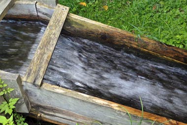 木製の樋を落下する水流