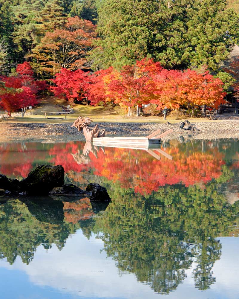 毛越寺大泉が池の水面に映える紅葉と龍頭鷁首の船