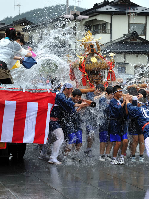 平泉駅前ロータリーで、小学生が担ぐ神輿にバケツの水が思いっきり掛けられます。